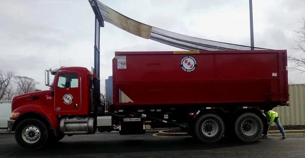 Red truck unloading roll off Container rental 